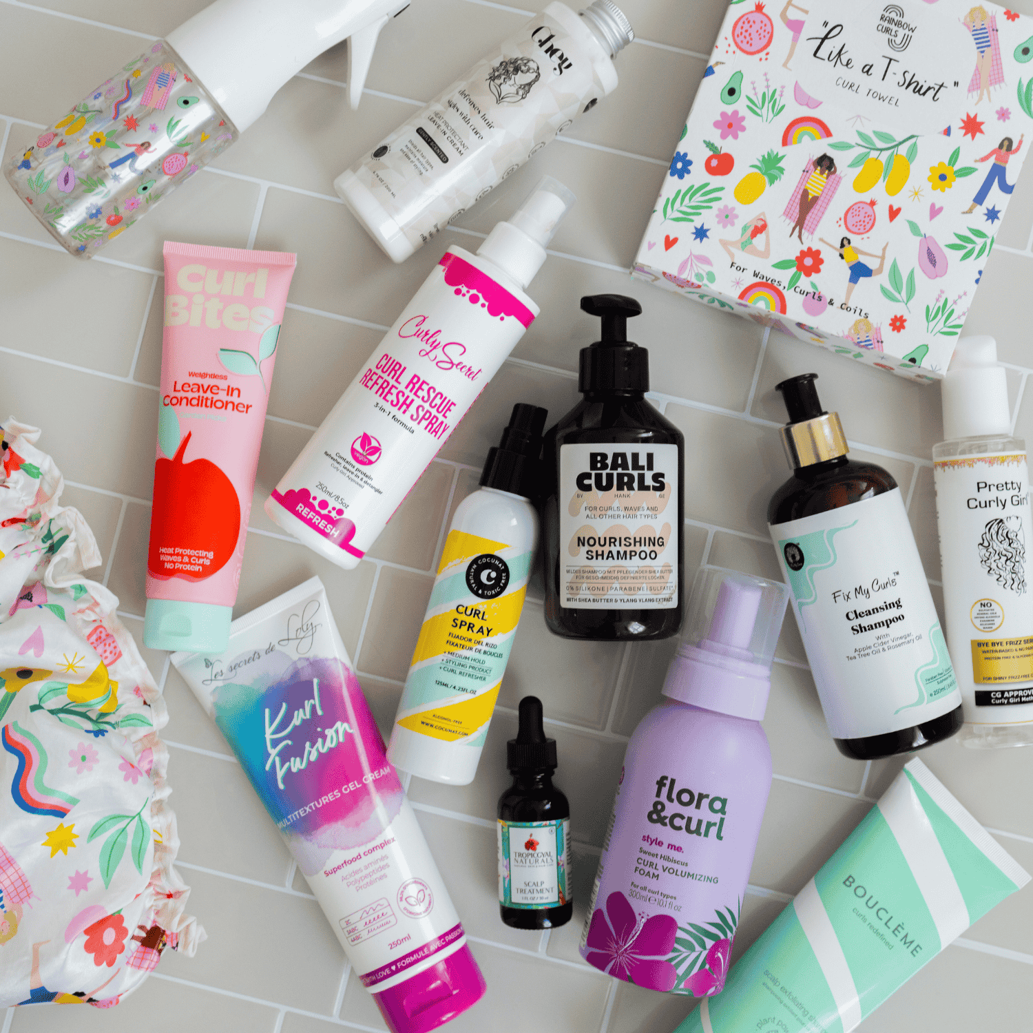 Zum Onlineshop - Verschiedene Lockenprodukten liegen flach auf einem gefliesten Hintergrund